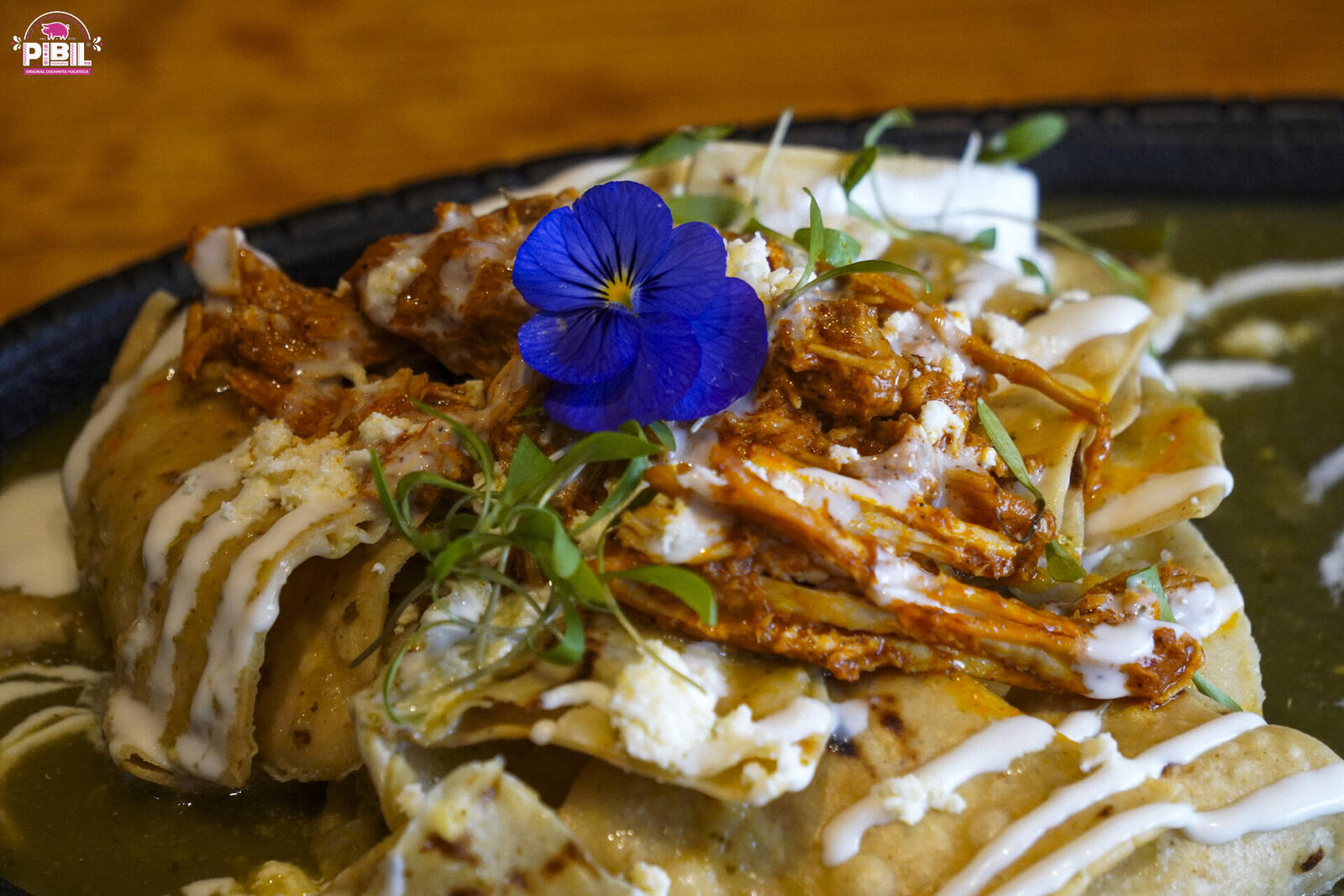 Chilaquiles con cochinita pibil, flor comestible y crema en Pibil Restaurante Cuernavaca